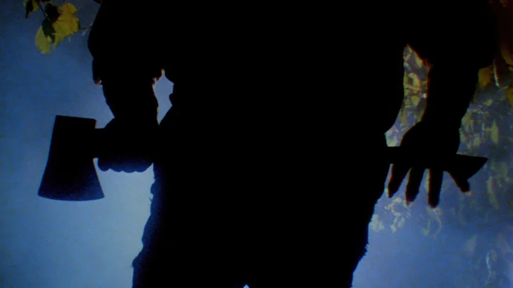 Silhouette holding an axe ominously.